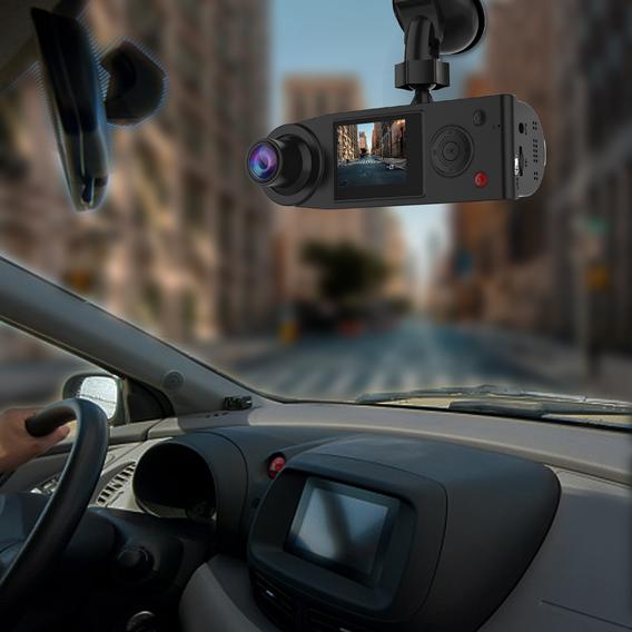 Dashboard camera mounted on car windshield recording urban street view with driver's hand on steering wheel