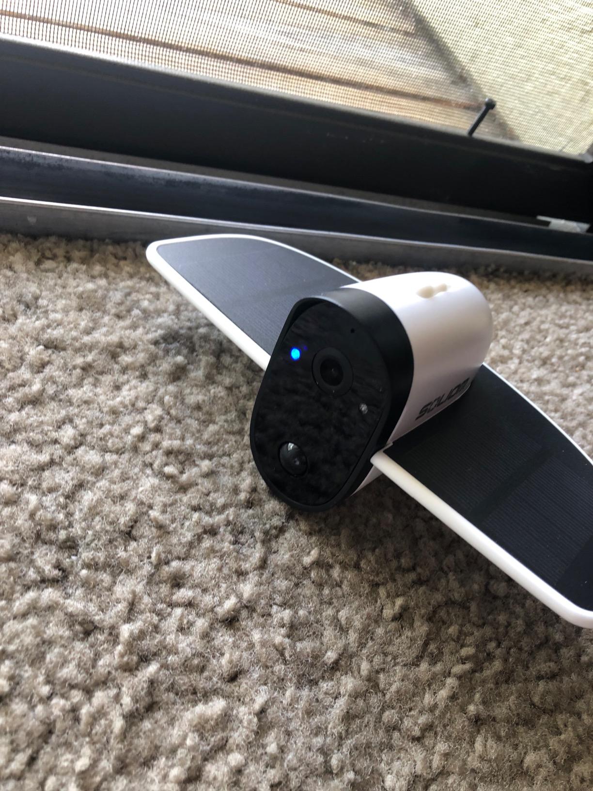 Indoor security camera with motion sensors on carpet near a closed sliding door
