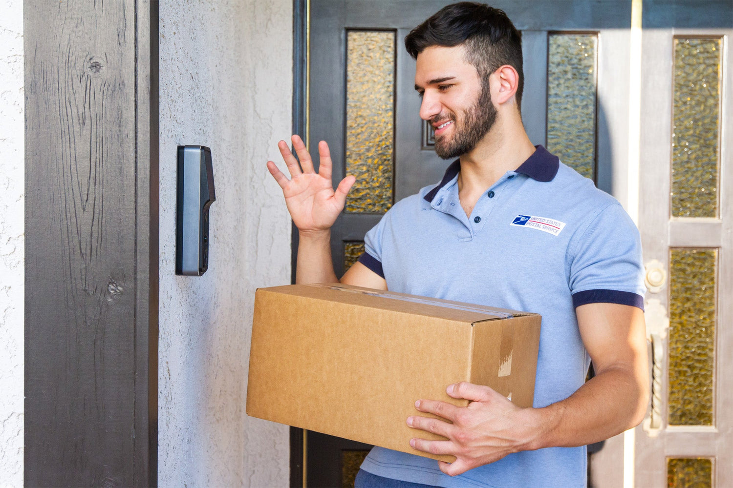 USPS mail carrier holding a cardboard package and pressing a doorbell at a house entrance