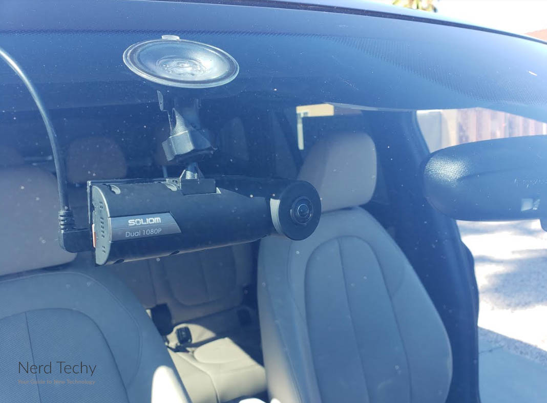 Soliom Dual 1080P dash cam mounted inside a car on the windshield near front seats