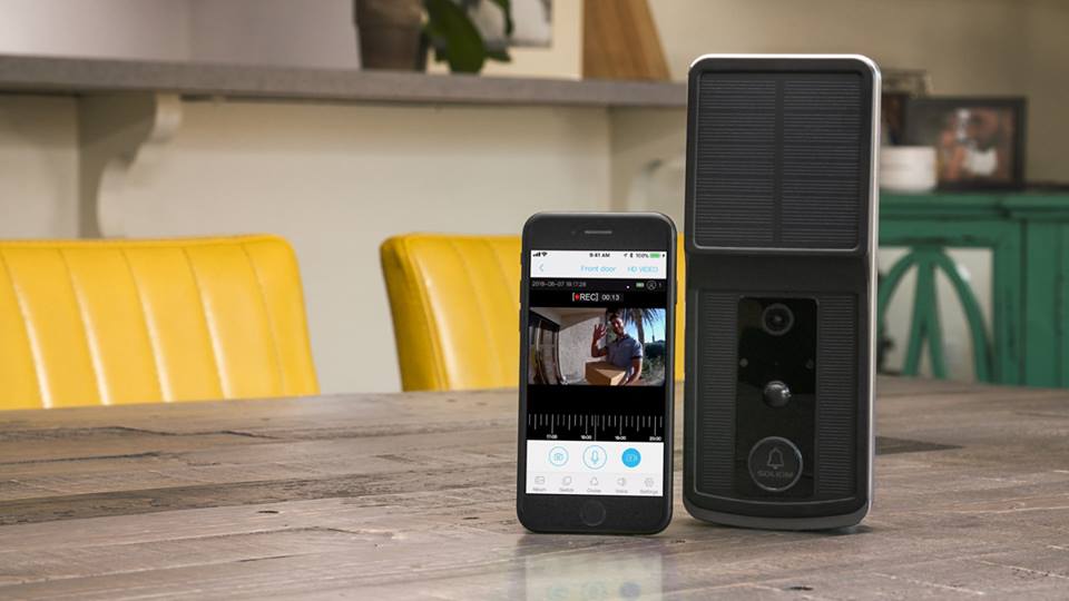 Smart home security video doorbell and smartphone showing live video feed of visitor on wooden table